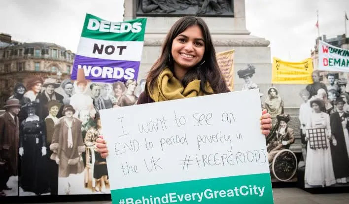 A student campaigner holding a #FreePeriods sign in Trafalgar Square
